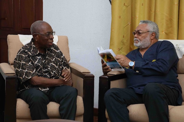 Rawlings taking a look at the book presented by Samuel Ntim Darkwa