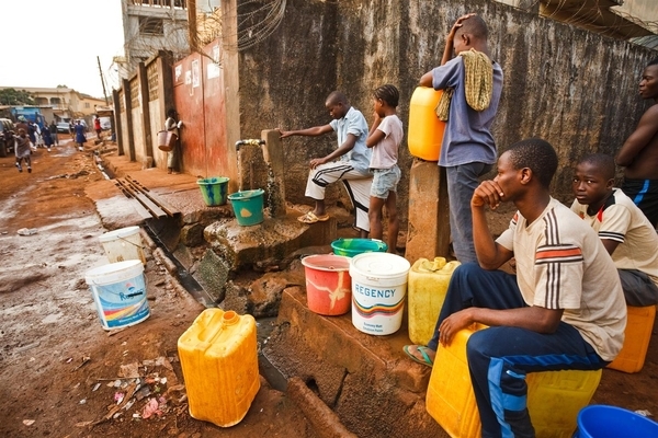 People fill containers from a communal tap in Freetown, Sierra Leone on Wednesday March 23, 2011.
