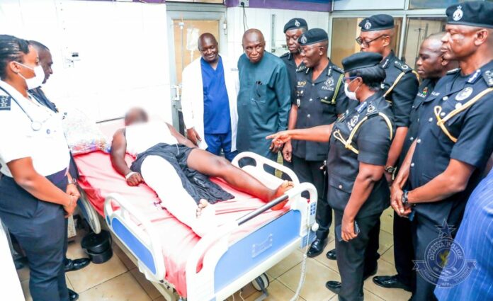 Ambrose Dery at the bedside of the injured police officer at the hospital