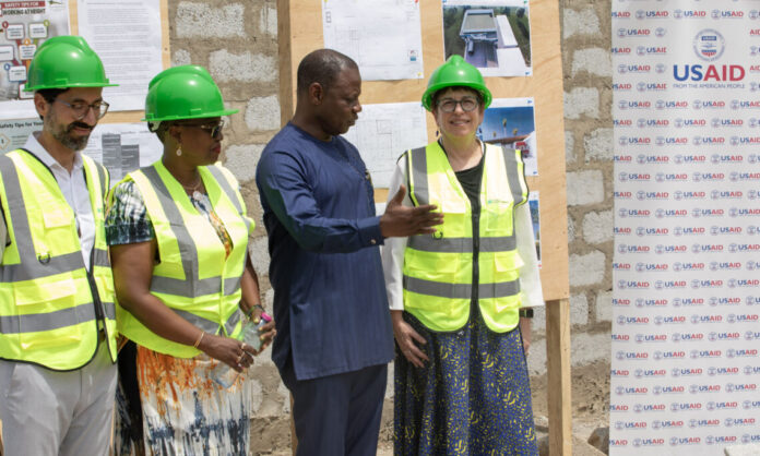 Deputy USAID-Ghana Mission Director Grace Lang and Ghana Health Service Director General Patrick Kumah Aboagye getting briefed on the features of the new Walk In Coldroom facility under construction.